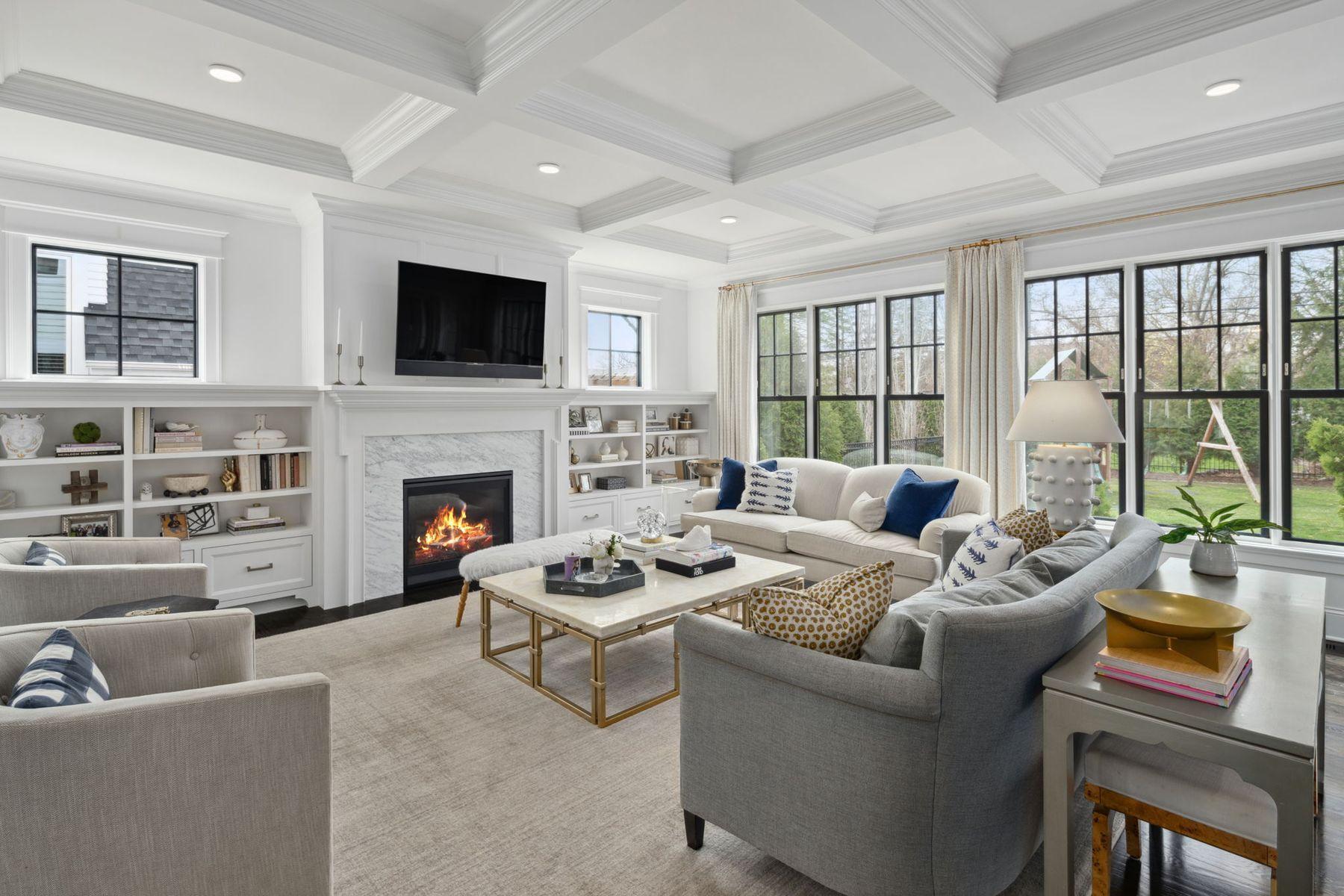 Living room with floor to ceiling windows and built in shelves.