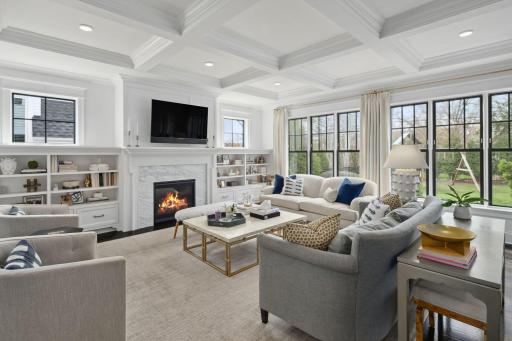 Living room with floor to ceiling windows and built in shelves.