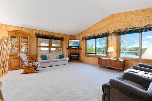 Spacious Living room with vaulted ceilings and lots of windows to view the lake! The living room is spacious and features vaulted ceilings, allowing for ample room to relax and entertain. Large windows provideof the lake, offering a tranquil and sere
