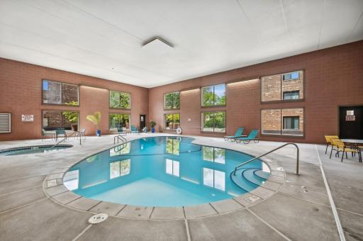 Indoor pool and hot tub area with high ceilings and natural light.