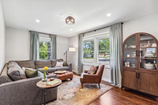 Living room has gorgeous hardwood floors, large windows, and wonderful natural light.