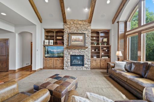 Wood beams and a stone fireplace top off this living room with over 10 foot ceilings