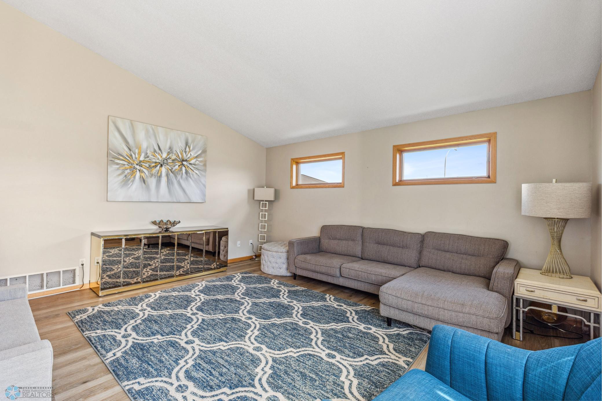 Living Room off of Kitchen, lots of light, newer flooring.