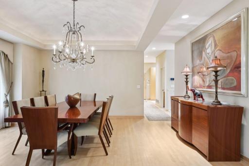 Formal dining room with stepped ceiling and subtle lighting
