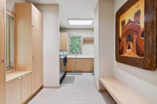 Expansive mud room with built in bench, storage adjacent to mainfloor laundry