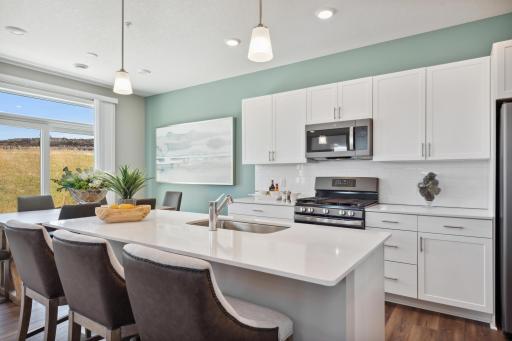 (Photo of decorated model, actual home's finishes will vary) Enjoy plenty of seating at the kitchen island and dining area adjacent to the kitchen. Perfect for entertaining or having a family meal together.