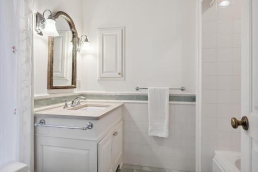 Bedroom ensuite, full bath showcases marble flooring and tile surround tub/shower