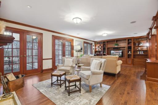 Gracious, open hearth to family room offers a variety of seating options and access to the both the paver patio/backyard and screened porch