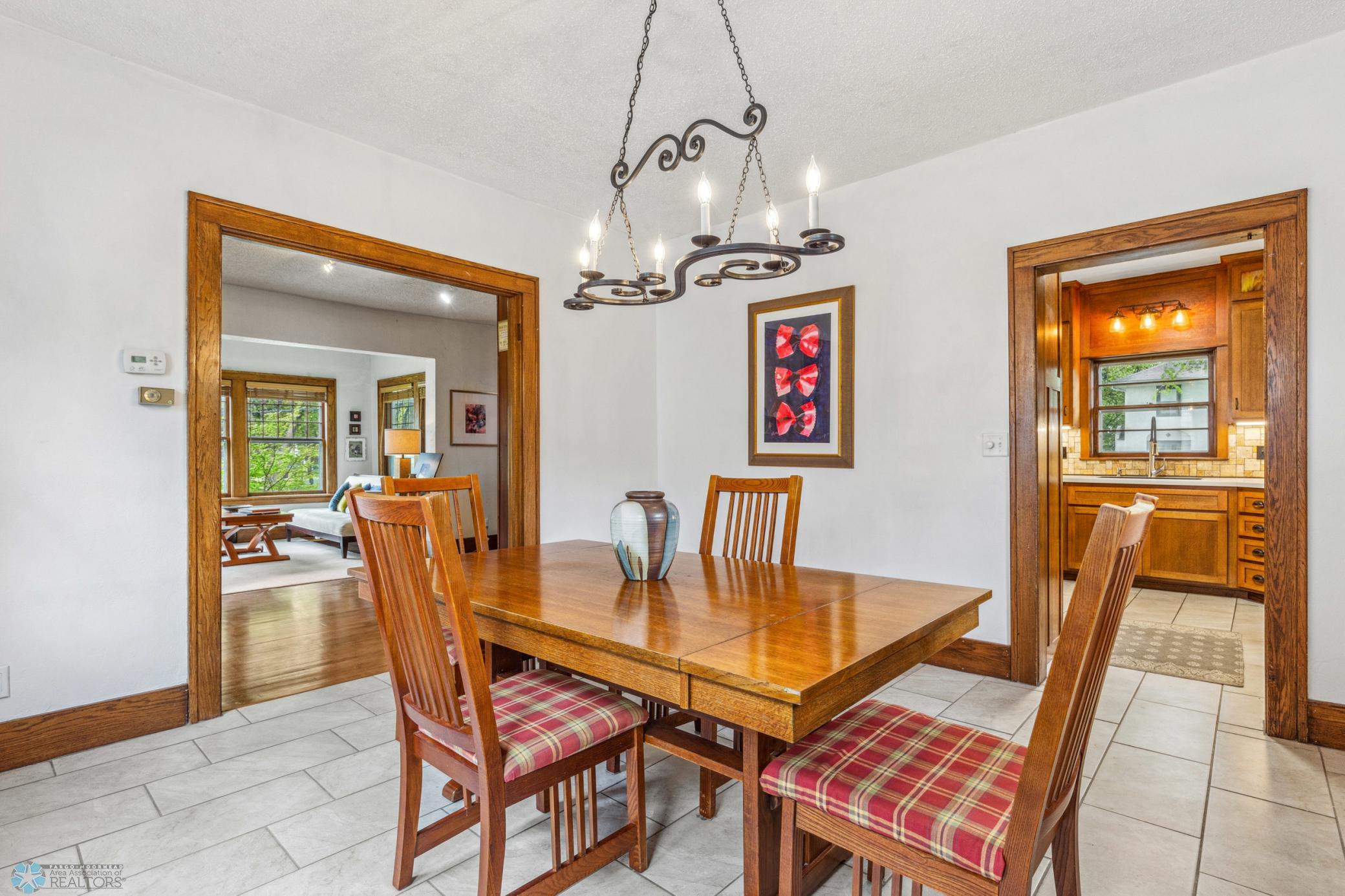Large open dining room with a view to the sunroom/living space, the kitchen and the gorgeous backyard