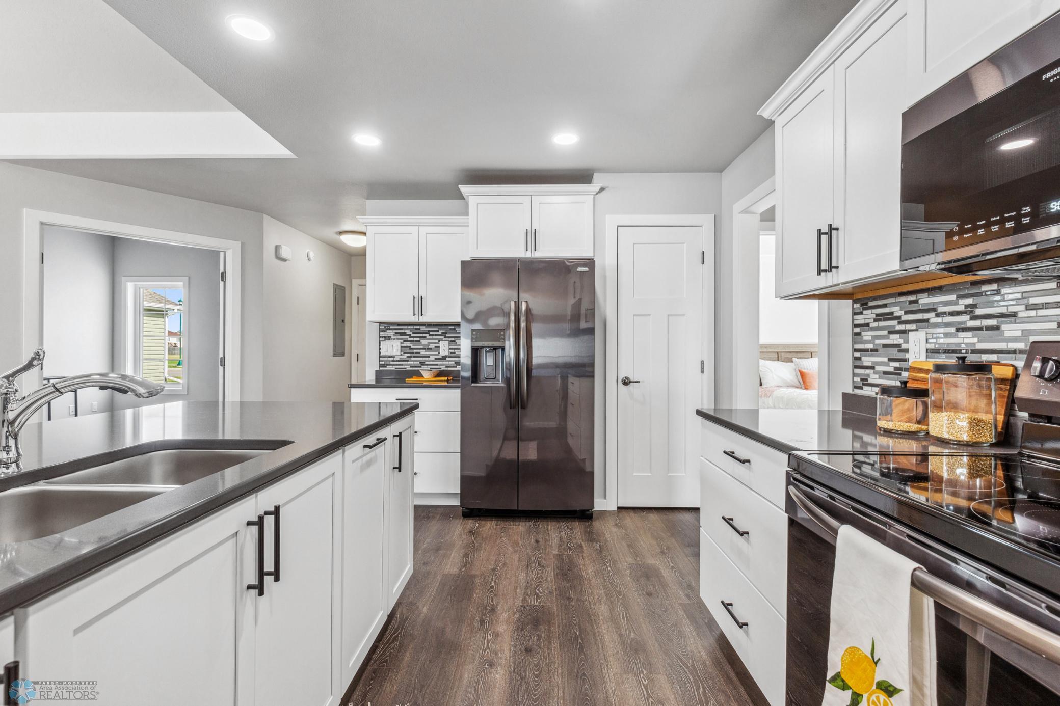Above- and Under- Cabinet lighting, tile backsplash & pantry. As well as quartz countertops and undermount stainless 2-bay sink.