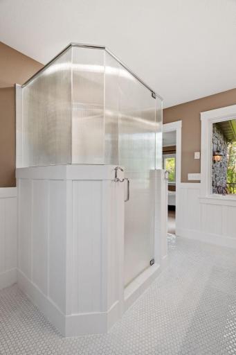 Separate shower features classic subway tile surround and frameless glass enclosure