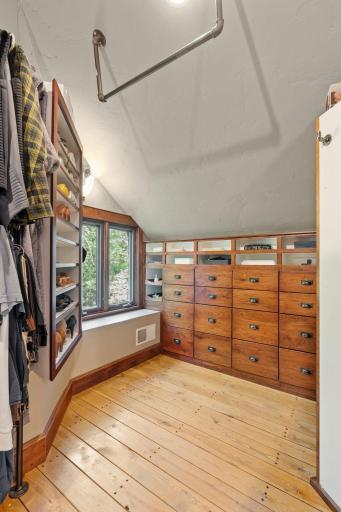 Walk-in closet features built-in dressing cabinet, shelves and ironing board