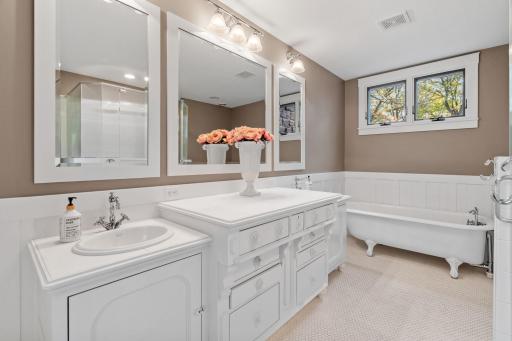 Private full bathroom has antique cabinets that serve as dual vanities with marble tile top and offer toe-kick enclosure. Mosaic tile flooring with radiant in-floor heating