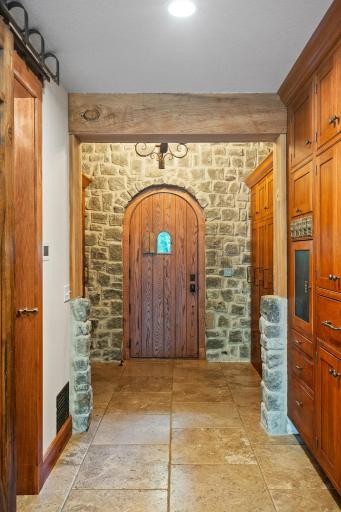 Cobblestone accent wall and rustic wood wrapped beams in the Informal Entry