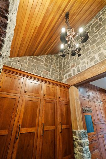 Custom built lockers offer a magnetic and cork message station behind each door. Partially vaulted with wood paneled ceiling and rustic chandelier.