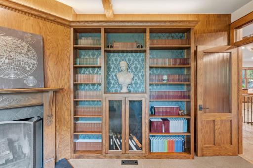 Built-in bookshelves with decorative accent walls, glass doors and accent lighting