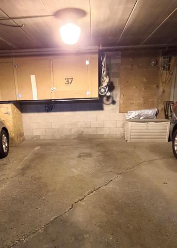 Parking stall in underground heated garage with storage cabinet.