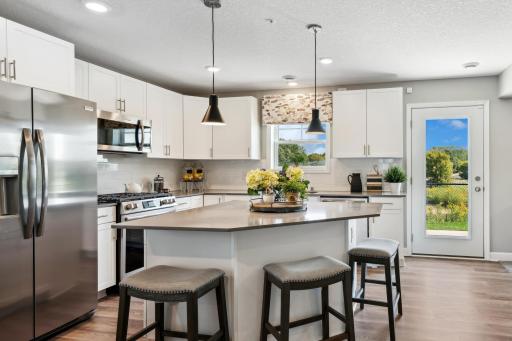 (Photo of a decorated model, actual homes finishes will vary) This kitchen features bar seating for casual meals from morning coffee to midnight snacks.