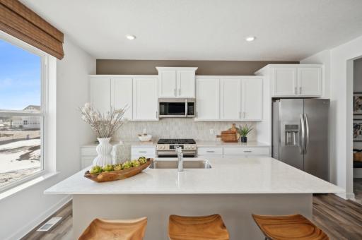 (Photo of model home, finishes will vary) Enjoy plenty of seating at the kitchen island and dining area adjacent to the kitchen. Perfect for entertaining or having a family meal together.