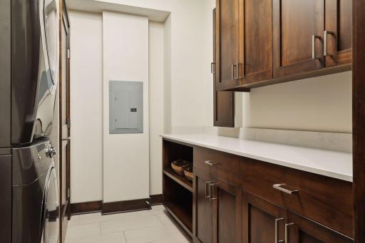 Laundry room with stackable units, long counter for folding, and great storage space