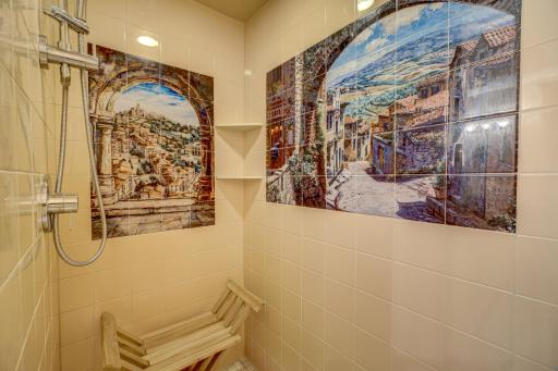 Spacious Master Walk-In Shower with Italy village scene tile design and recessed lighting