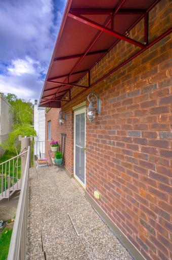 Side veranda with access to back sprial stairs leading to the open shared green space. Great place for a small vegetable or flower garden.