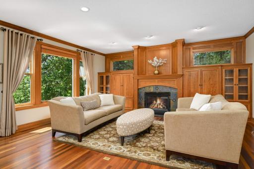 A cozy gas fireplace in the great room is flanked by elegant transom windows and custom built ins.
