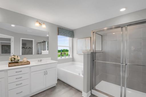 The primary bath features a separate soaking tub, walk-in shower and TWO walk-in closets! Model photos. Options and colors will vary.