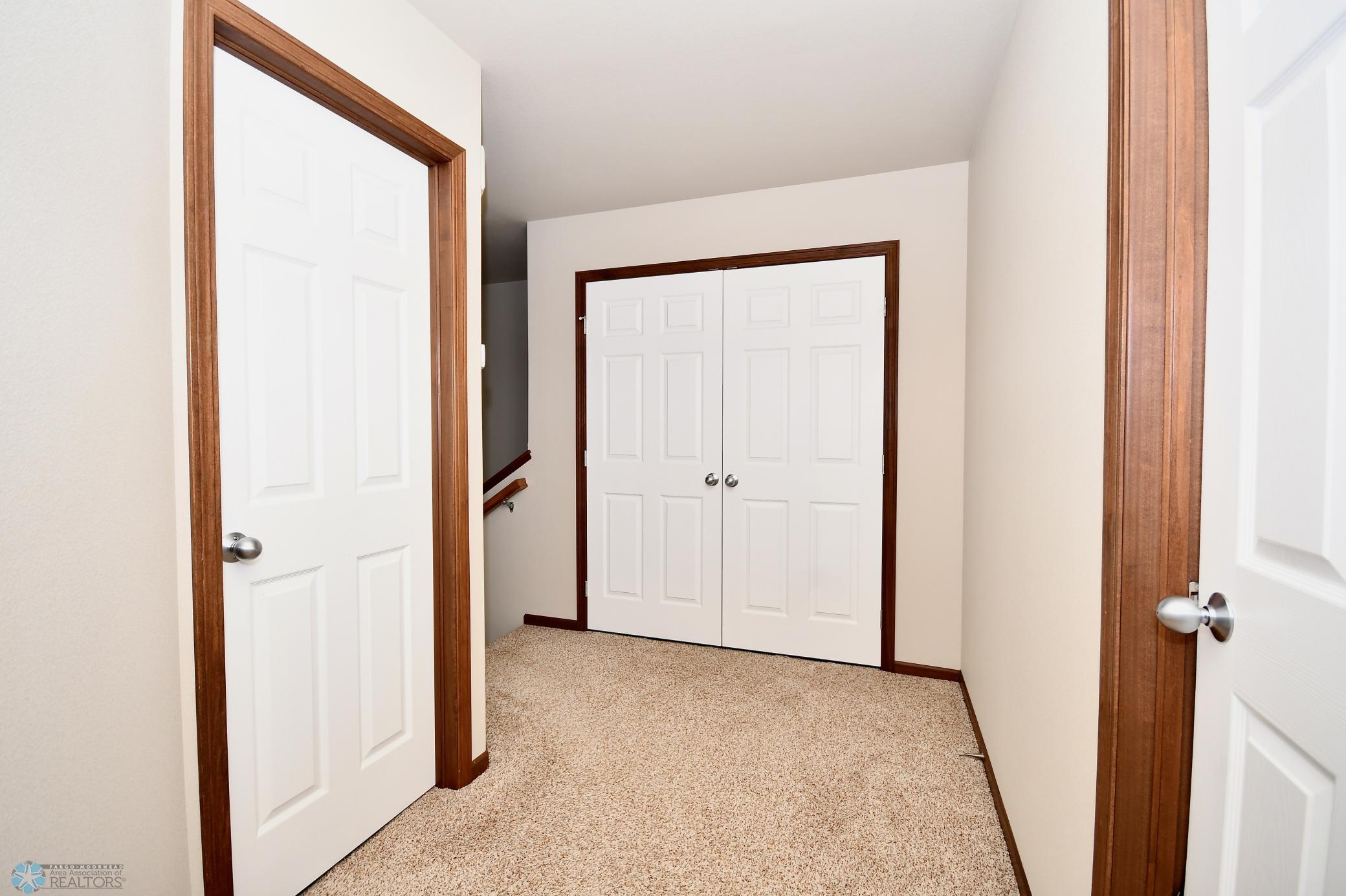 Upper Level Hallway with View to Bath & Double Closets to Laundry