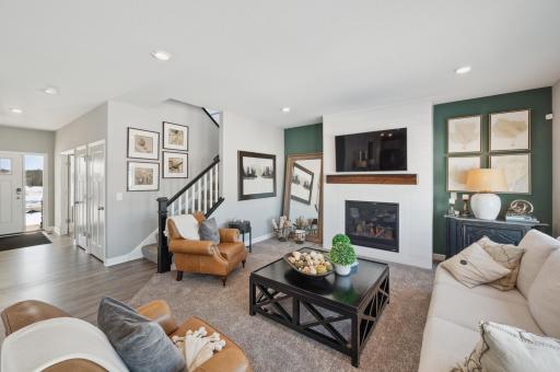 (Photo of model home, actual features may vary) Elegant windows provide an abundance of natural light to flow throughout the main level, including this nicely sized family room, featuring a natural gas fireplace.