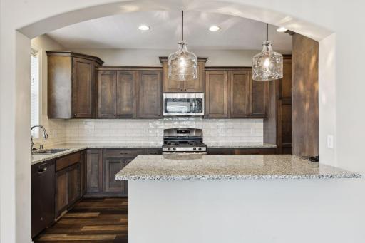 Kitchen features SS appliances, tiled backsplash and ample cabinet space for storage