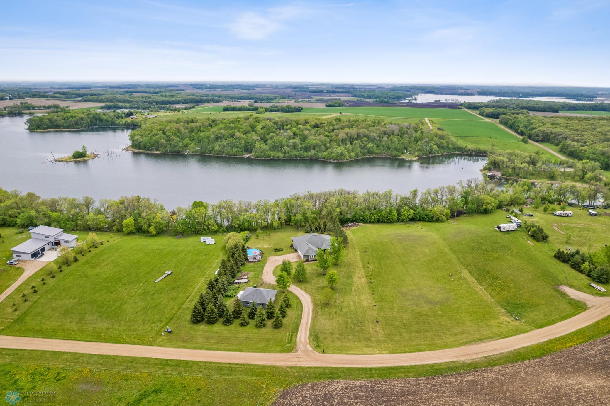 Aerial View: Mature shelterbelt of varying trees - beautiful year-around. Vacant lot to the west (immediate right) is also available for sale, separately.