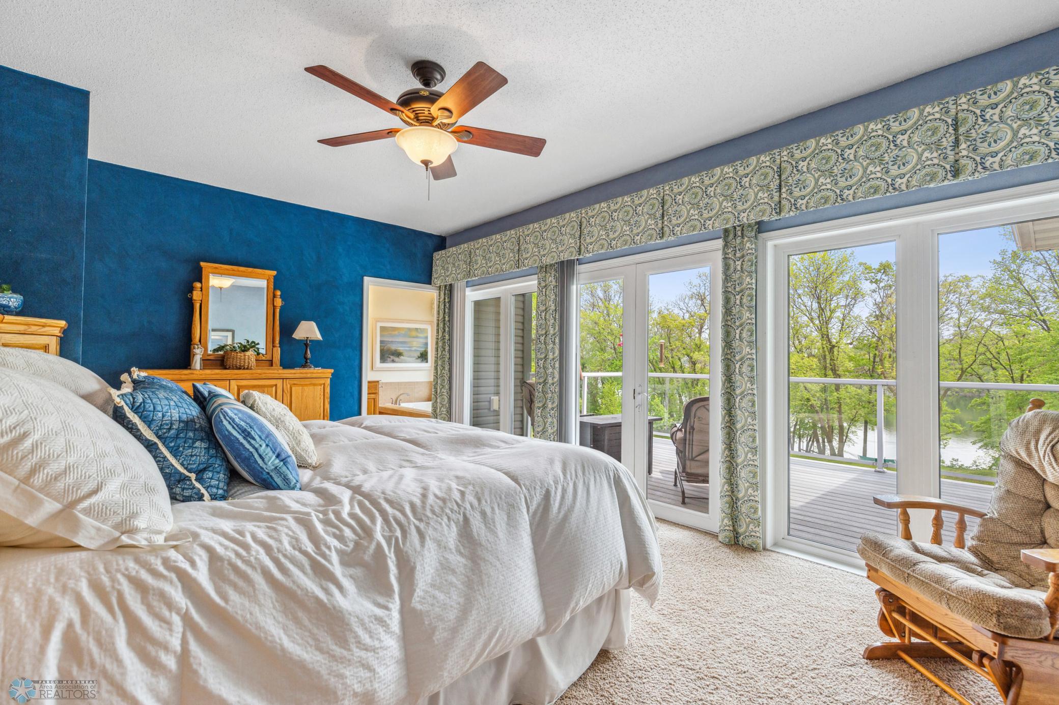 Primary Bedroom has sliding doors for incredible lake views and access to one of two decks. Also: large walk-in closet and private bath with separate soaking tub and shower.