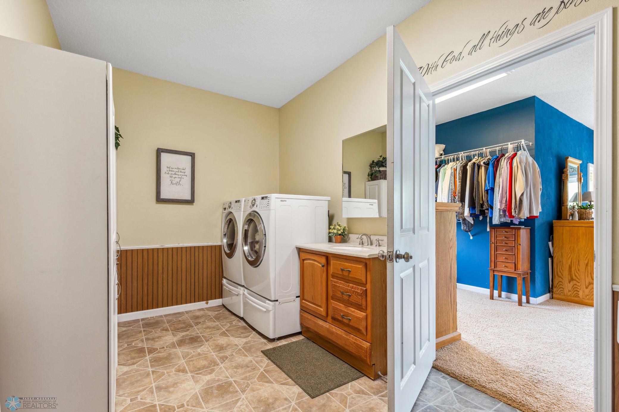 Main floor Laundry room with folding counter, cabinetry and sink.
