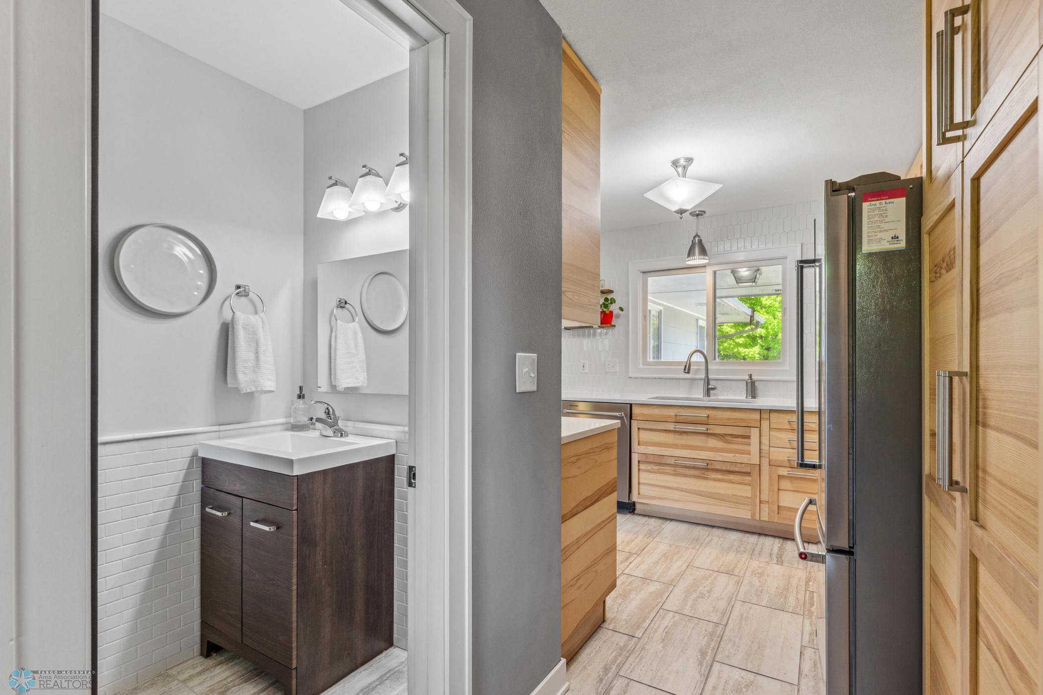 Main floor half bath is located near garage and backyard entry and to the rear of the kitchen.