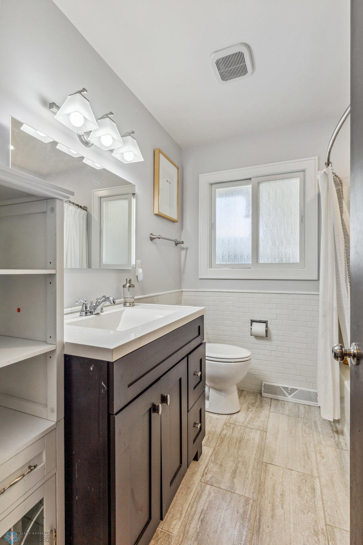 Main floor full bathroom - has been updated w/ seamless tub/shower surround and wifi fan/light/speaker