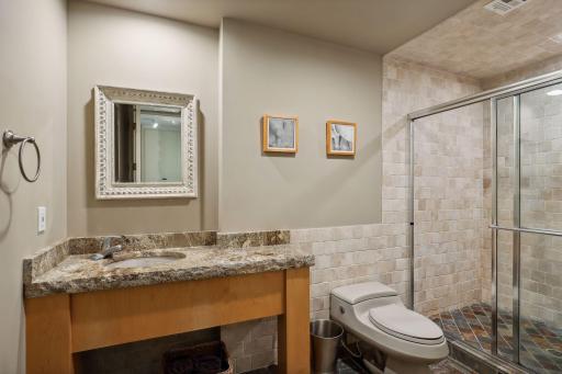 3/4 lower level bath located by bar area with a stacked washer/dryer for bedrooms