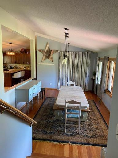 Dining room with mahogany floor and stairs to upper & lower level.