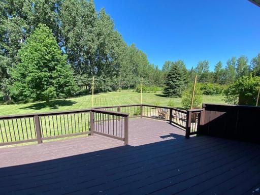 Spacious backyard deck surrounded with trees for a private place to enjoy.