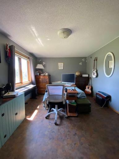 Upper level bedroom or office space with large window for natural light.