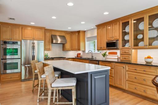 The kitchen offers a large center island with quartz counters and stainless appliances