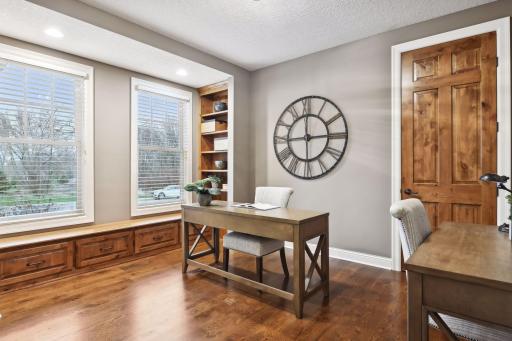 Office includes a closet as well as built-in shelving and a window seat with drawers for extra storage.