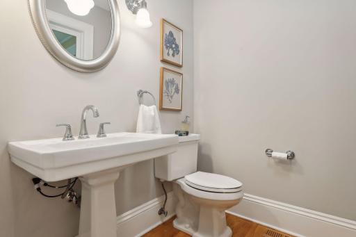 Main level powder room with hardwood floors and timeless styling and details.