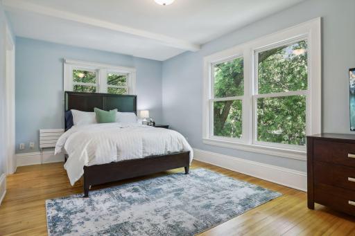 The original primary bedroom with is on the second story with large windows and ensuite bathroom.