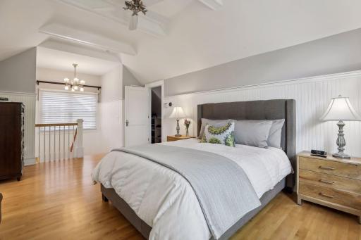 Another view of the primary bedroom and large windows with tall ceilings.