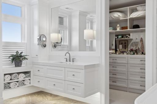 The meticulously designed walk in closet combines practicality with elegance. Thoughtfully placed hanging rods and built in cabinetry will keep you well organized.