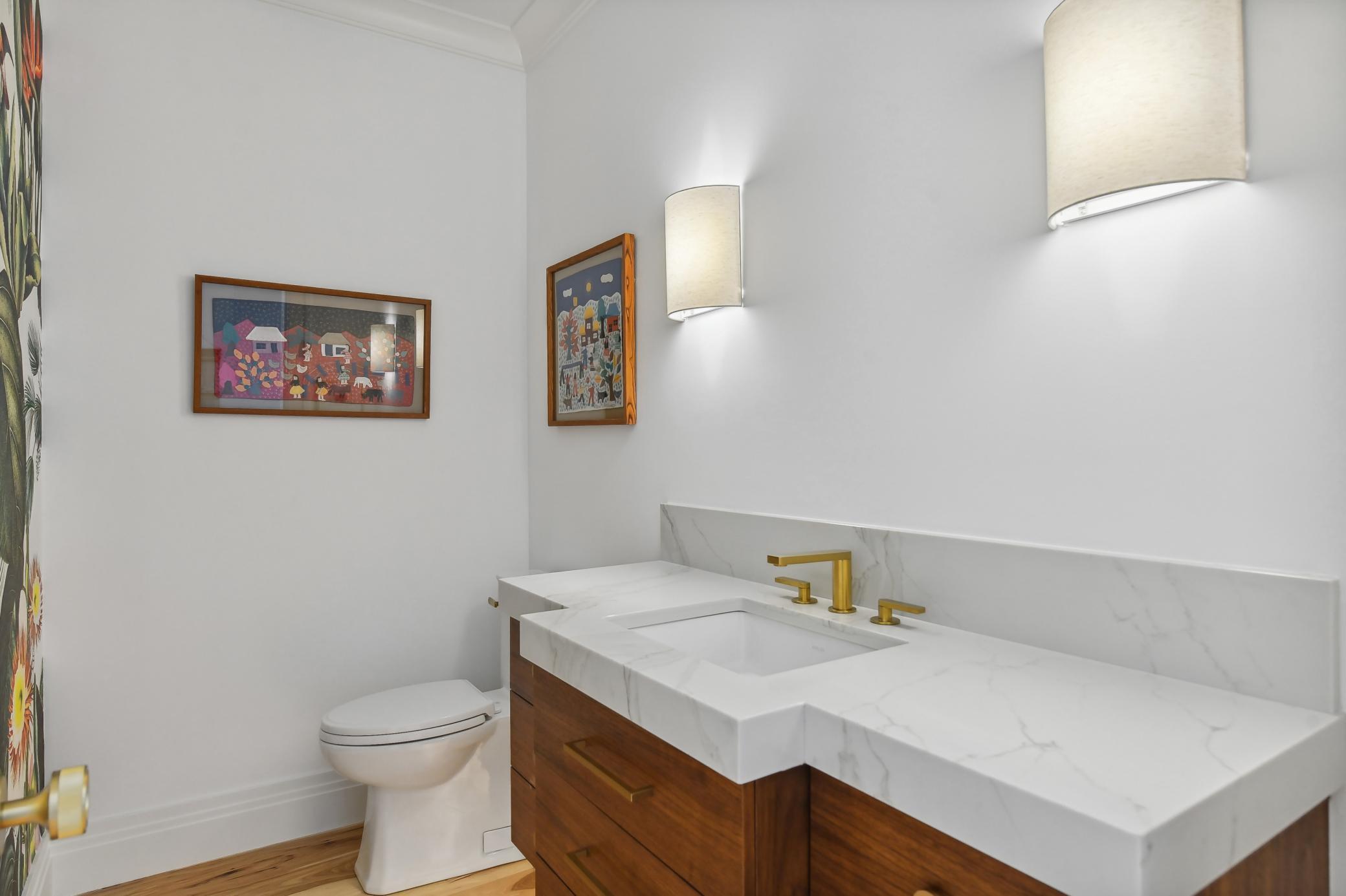 The powder room, conveniently located off the foyer is stunning! It's a reflection of the quality and thoughtfulness weaved throughout this spectacular home. YES! We've added a mirror!
