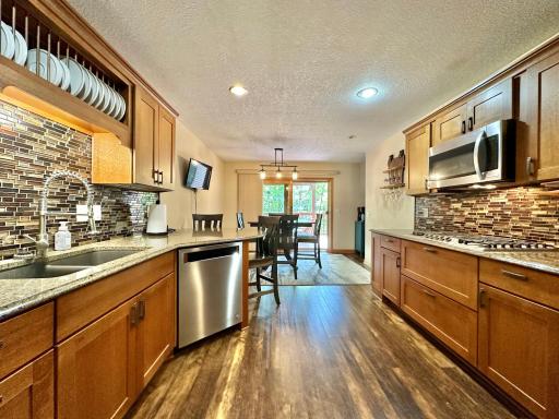 Look at this gorgeous kitchen. It boasts cherry cabinets, tile back splash, under the counter lighting, granite counter tops and stainless appliances.