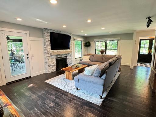 Cozy living room with wood burning fireplace, custom mantle, and built-in TV nook