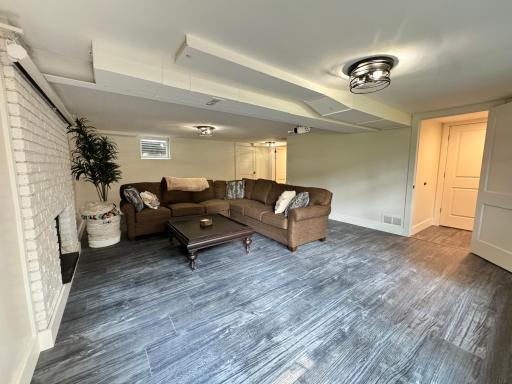 Basement level living room with floating floor and wood burning fireplace.
